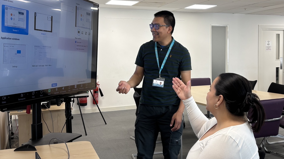 nine working with a participant at the bring your own tech day