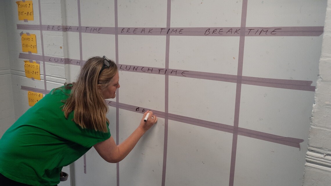 Photo of Kate marking out the space on the wall prior to the participatory agenda setting